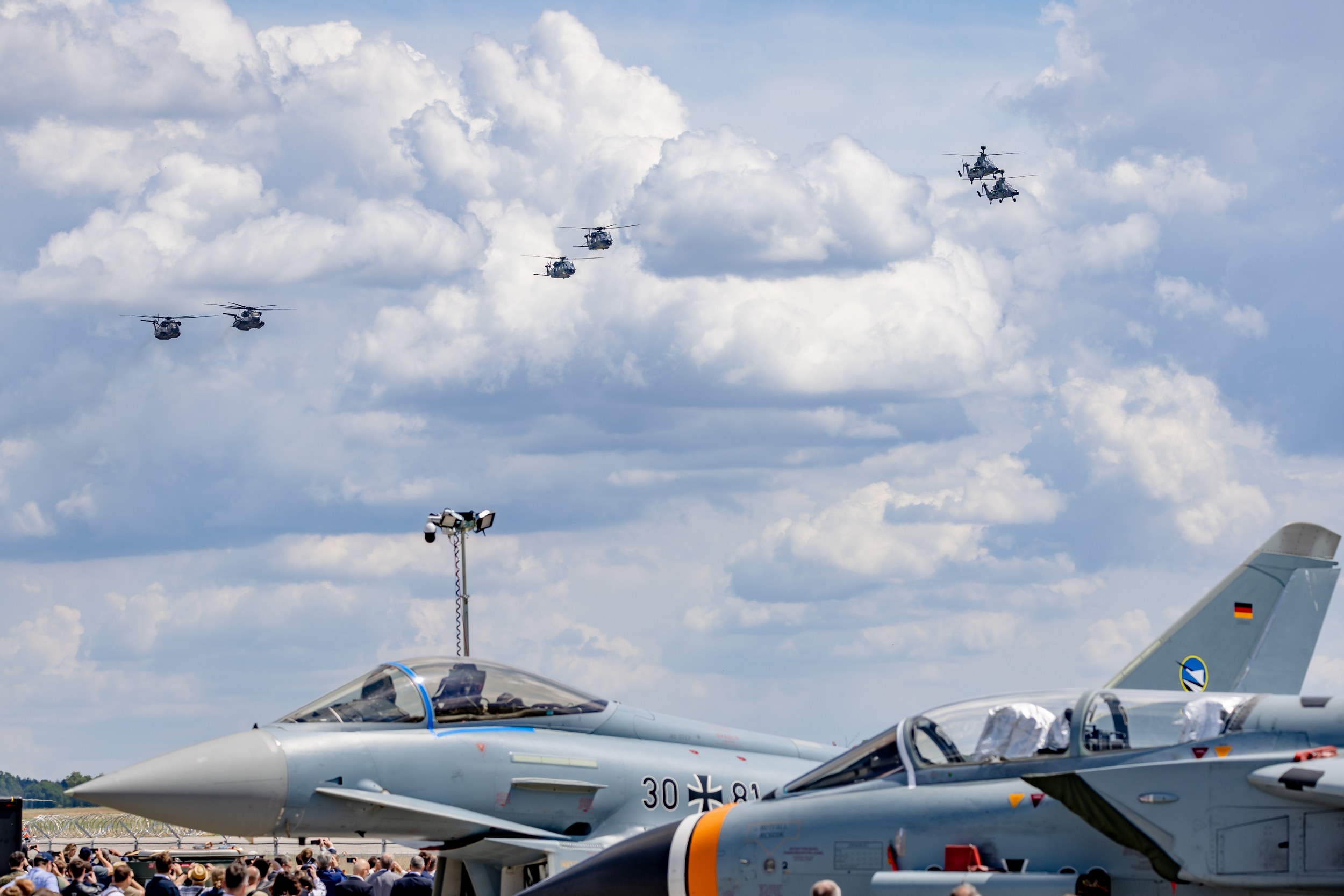 A Eurofighter Typhoon marked 30+81 and a cropped Panavia Tornado stand in the static display before a crowd of visitors.