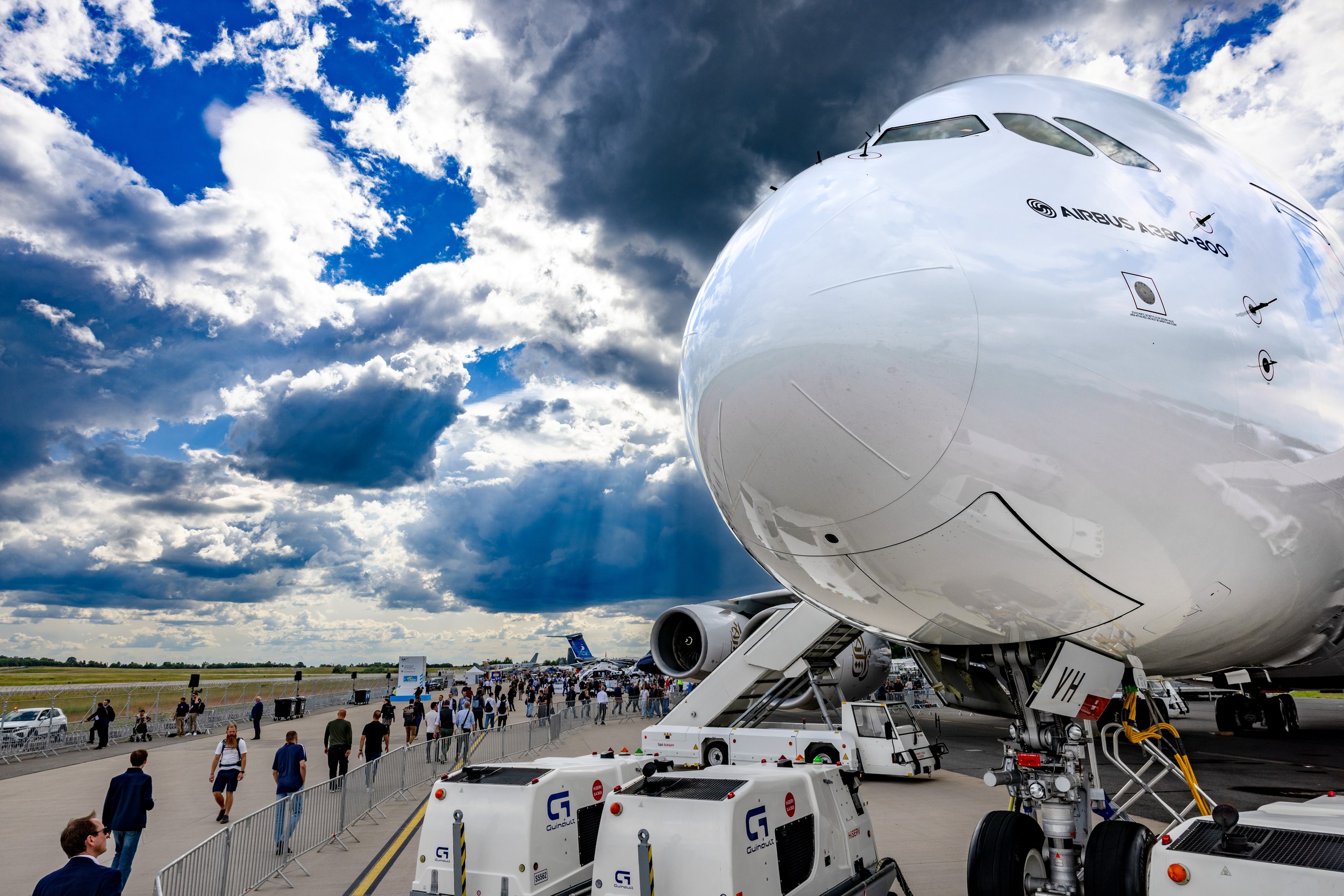 The white nose of an Airbus A380-800 dominates the static display in a low, wide-angle view on the ILA outdoor grounds.
