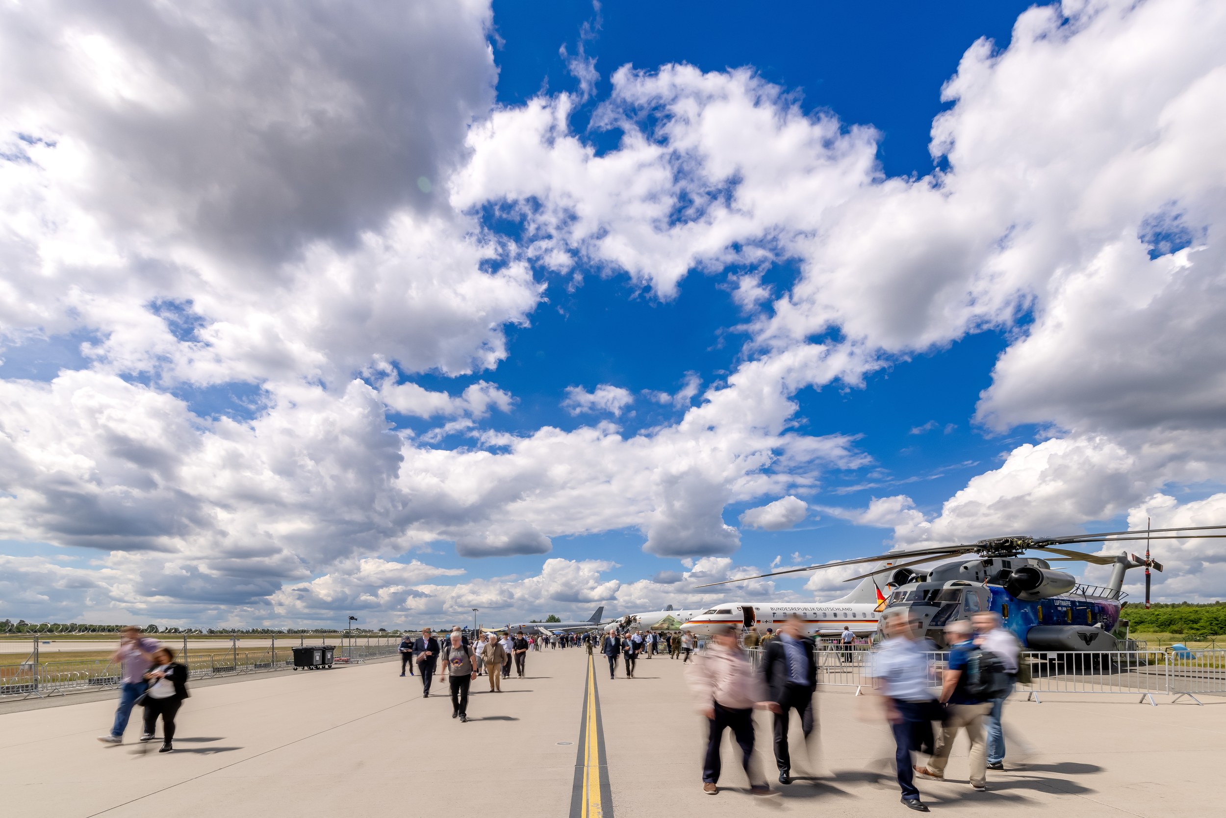 Runway panorama of ILA 2026 with visitors under a cloudy sky