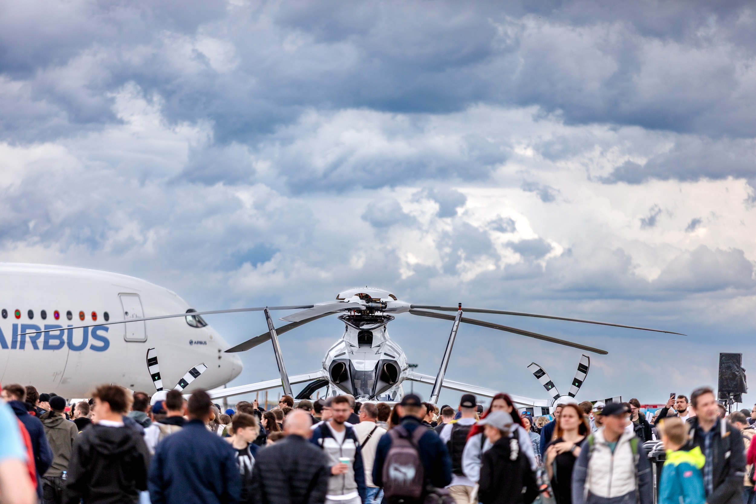 The Airbus Helicopters Racer High Speed Demonstrator stands head-on behind a dense crowd in the static display.