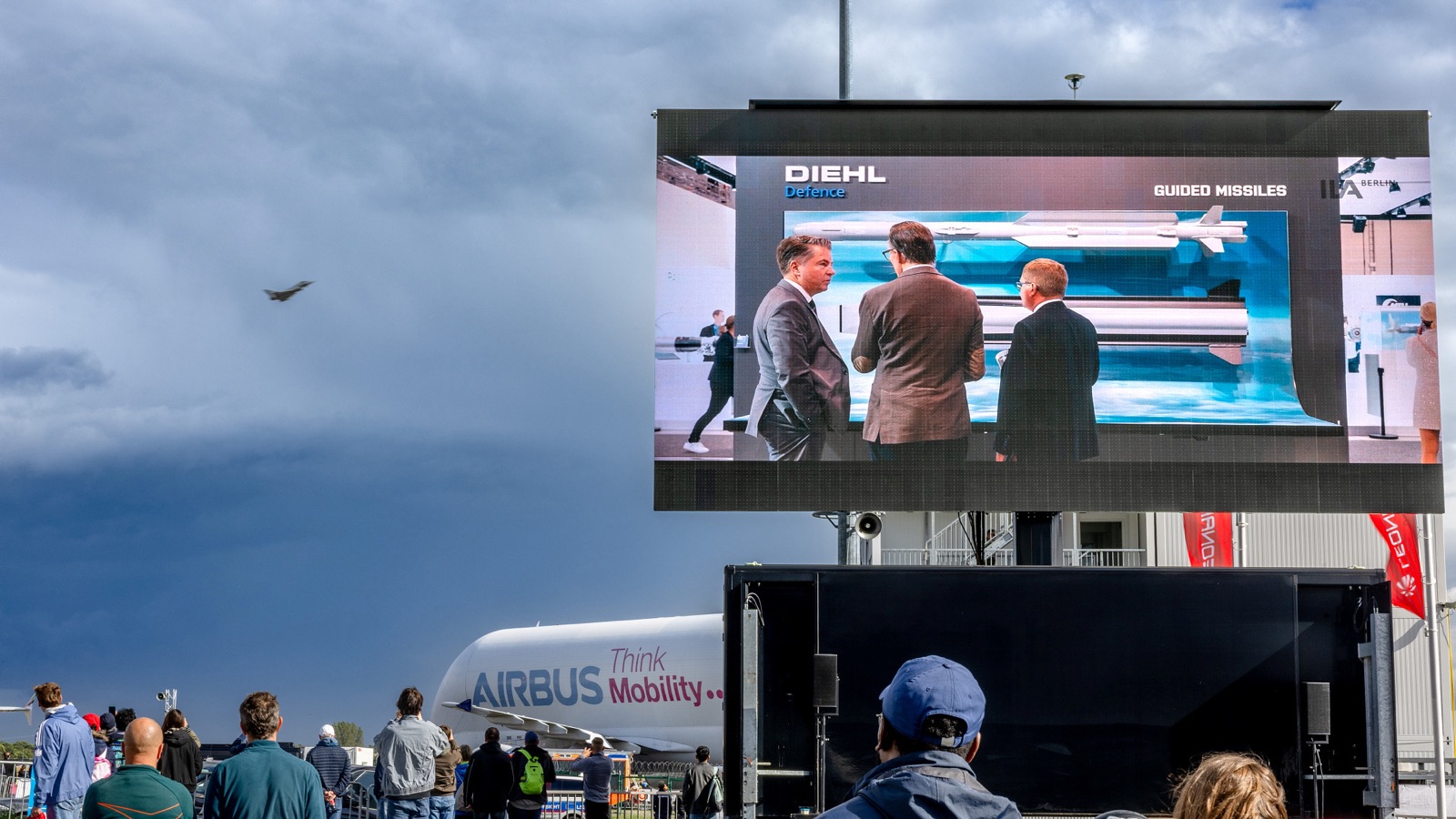 Large LED wall showing brand content in front of visitors and an Airbus BelugaXL on the ILA Berlin 2026 open-air grounds.