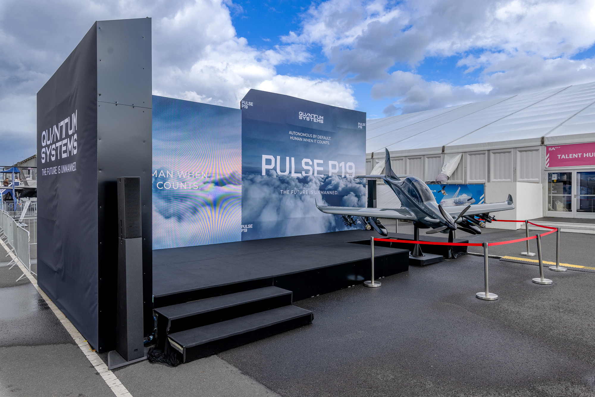 Quantum Systems PULSE P19 on the presentation stage in front of the branded wall