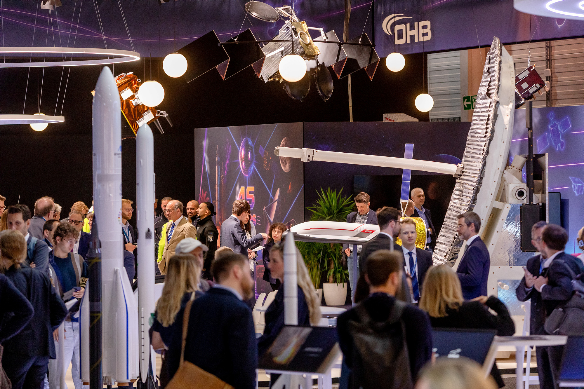 Satellite models above a dense trade audience at the OHB stand