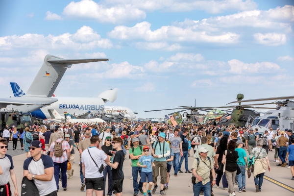 Ein Rollfeld voller Besucher, die zwischen geparkten Flugzeugen herumlaufen.